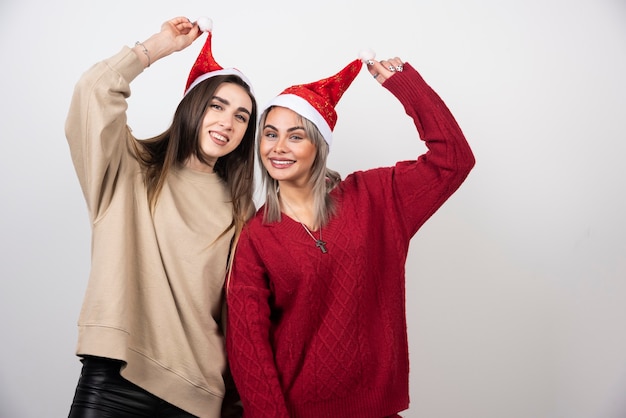 Image d'une femme heureuse tenant un chapeau de Père Noël.