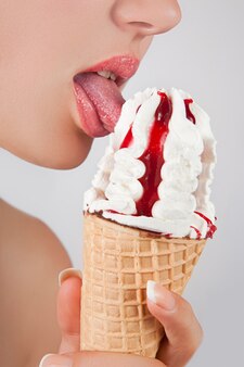 L'image en gros plan d'une femme mange sa glace savoureuse préférée