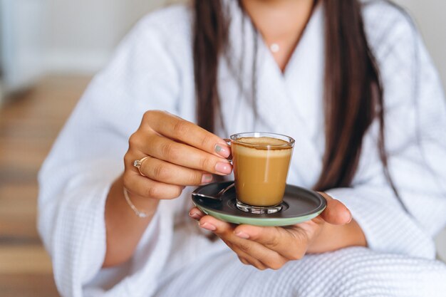 Image en gros plan d'une femme tenant une tasse de café.