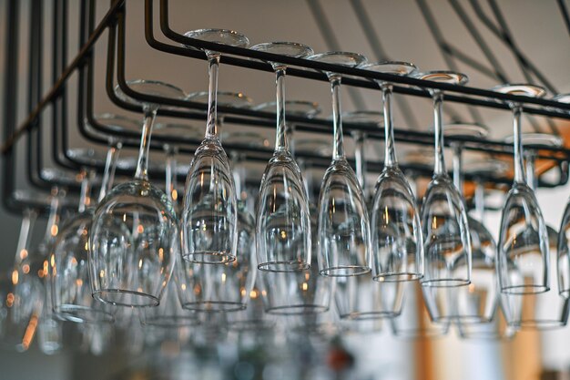 Image en gros plan d'un verres à vin suspendus dans le bar au-dessus du comptoir du bar.