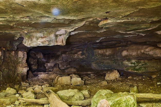 Image d'une grotte au toit presque plat avec de gros rochers éparpillés sur le sol
