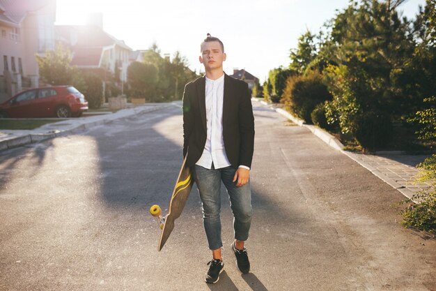 Image d'un homme avec longboard sur route