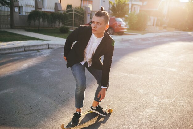 Image d'un homme avec longboard sur route