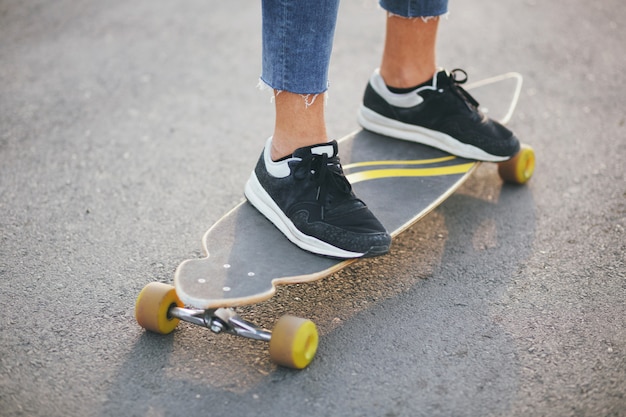 Image d'un homme avec longboard sur route