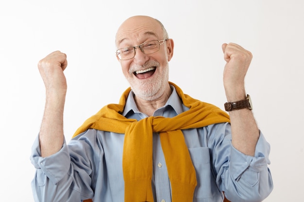 Photo gratuite image d'un homme mûr heureux se sentant ravi et excité après avoir gagné à la loterie, s'exclamant joyeusement, serrant les poings. les gens, la chance, le succès, l'excitation, la victoire, la victoire et la bonne fortune