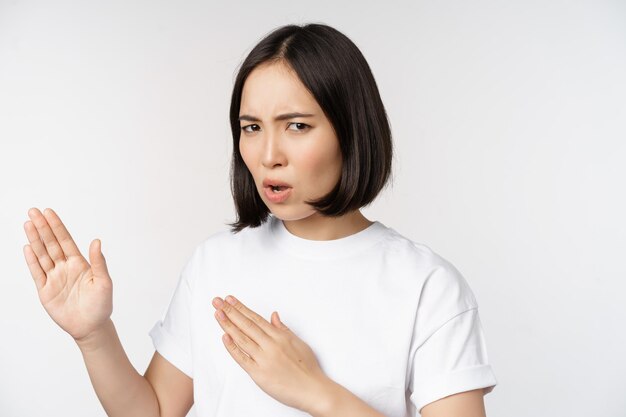 Image d'une jeune femme asiatique impertinente debout dans un combat de karaté pose un combattant d'arts martiaux debout sur fond blanc