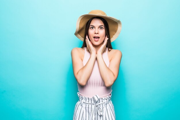 Image d'une jeune femme excitée choquée debout isolée sur un mur bleu. Regardant la caméra.