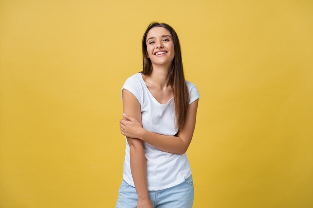 Image d'une jeune femme excitée debout isolée sur fond jaune. Regarder la caméra.