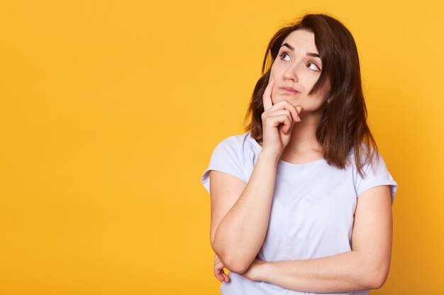 Image de jeune femme intelligente réfléchie à la recherche de côté