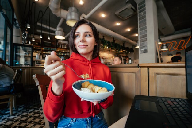 Image de jeune femme souriante heureuse s'amuser et manger de la crème glacée dans un café ou un restaurant closeup portrait