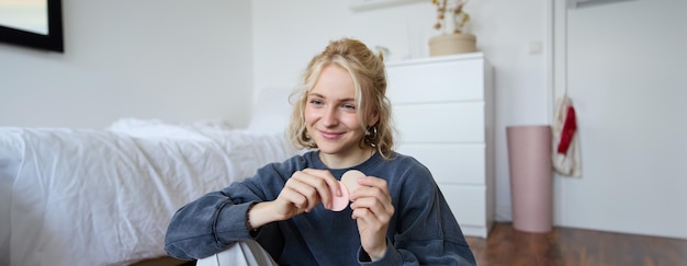 Photo gratuite image d'une jeune femme vlogger enregistre une vidéo sur une caméra numérique montrant des produits de beauté recommandés