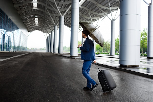 Image - jeune, homme affaires, tenue, valise, et, parapluie, à, pluvieux, terminal