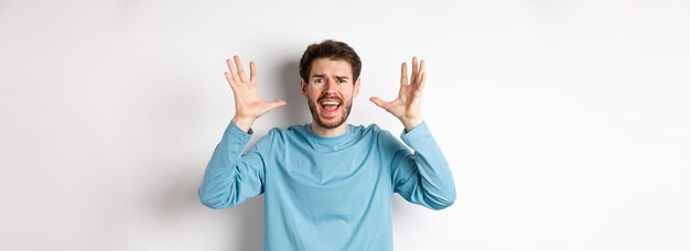 Image d'un jeune homme paniqué criant et serrant la main en criant à la caméra frustré ou inquiet