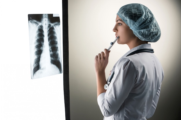 Photo gratuite image de jolie femme médecin regardant les résultats de radiographie