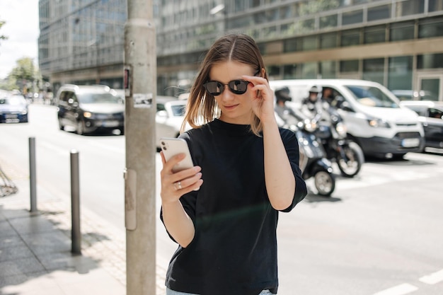 Image de jolie jeune femme souriante au téléphone en lunettes de soleil