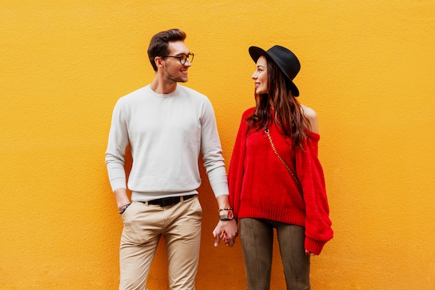 Image de mode automne d'un couple élégant et élégant amoureux se tenant la main et se regardant avec plaisir.