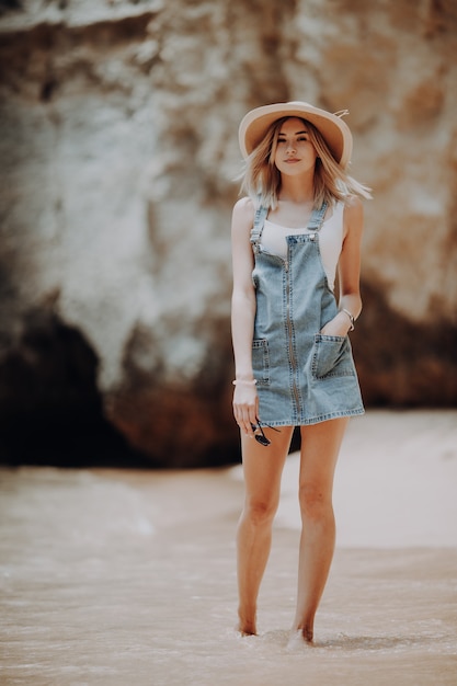 Image de mode de vie d'été d'une femme étonnante heureuse marchant sur la plage de l'île tropicale.