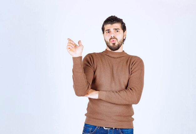 Image d'un modèle de jeune bel homme debout et pointant vers le haut. photo de haute qualité