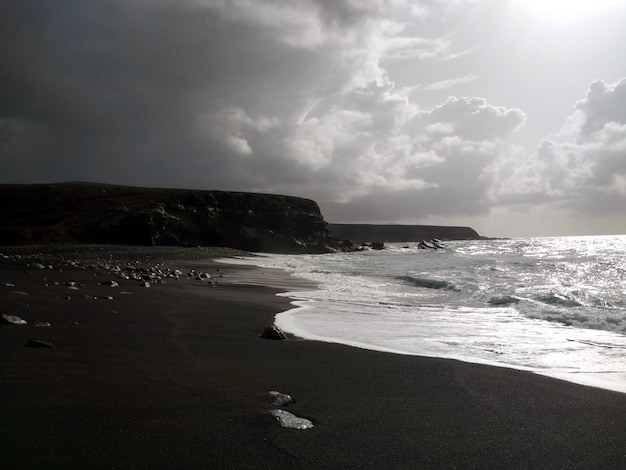 Image en noir et blanc de vagues calmes sur la côte