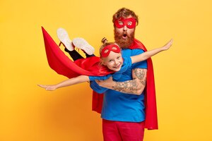 Image de père et fille au gingembre habillés en super-héros