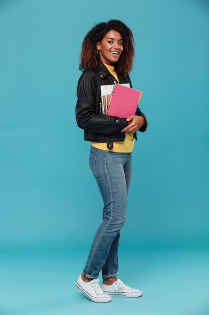 Image pleine longueur de femme africaine souriante en veste en cuir