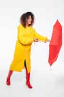 Photo gratuite image pleine longueur de jeune femme africaine en parapluie d'ouverture imperméable
