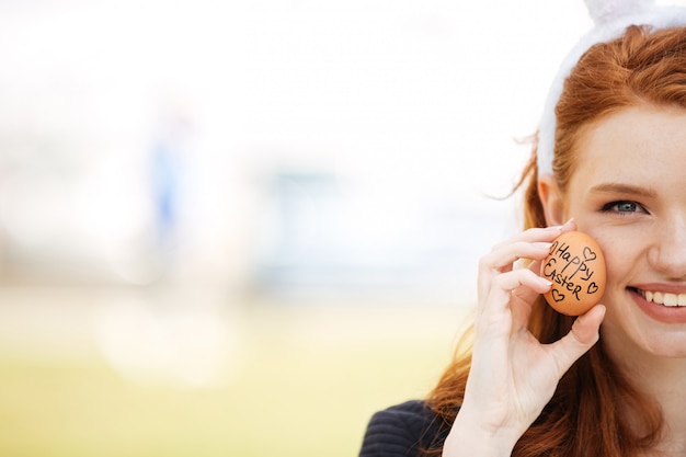 Image recadrée demi visage d'une jeune femme rousse