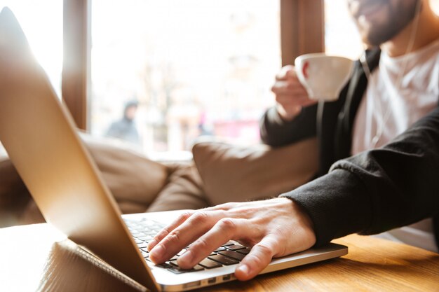 Image recadrée d'homme barbu dans un café près de la fenêtre