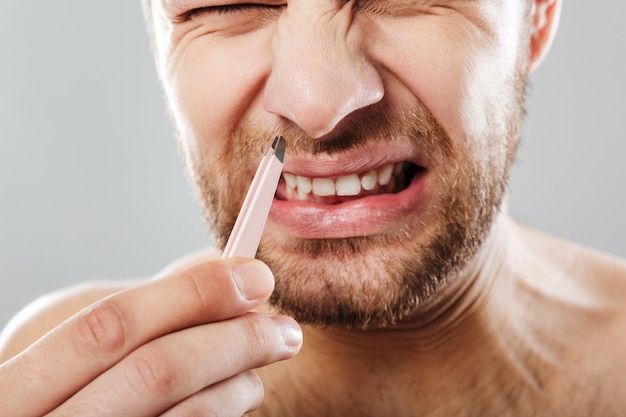 Image recadrée d'un homme fronçant les sourcils dans la douleur