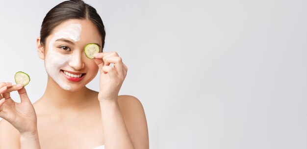 Image de soins de la peau beauté jeunes femmes asiatiques avec concombre sur fond blanc studio