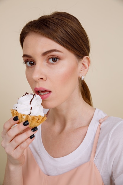 Image verticale de femme mangeant un gâteau