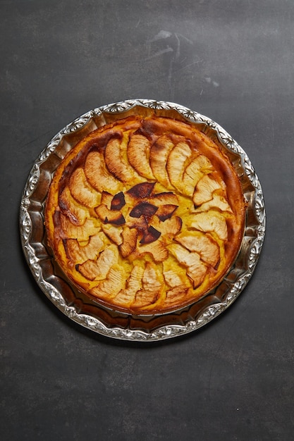 Photo gratuite image verticale d'un gâteau aux pommes sur une surface grise