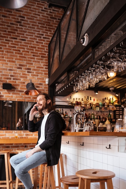 Photo gratuite image verticale d'un homme assis sur un bar