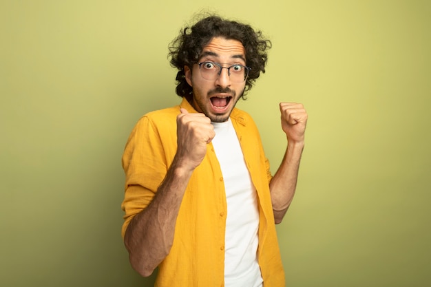 Impressionné jeune bel homme caucasien portant des lunettes debout en vue de profil en regardant la caméra pointant vers lui-même isolé sur fond vert olive avec espace copie