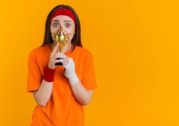 Impressionné jeune femme sportive portant un bandeau et des bracelets