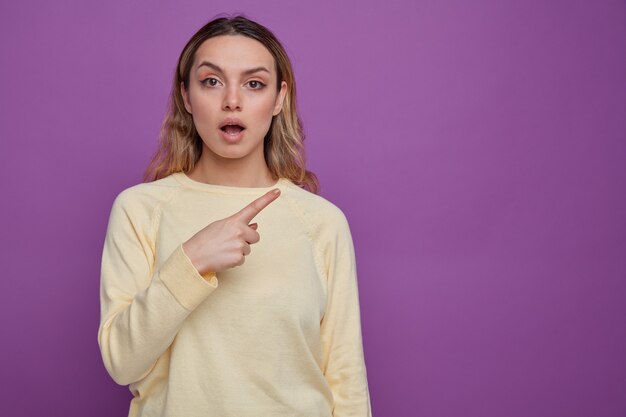 Impressionné jeune fille pointant sur le côté