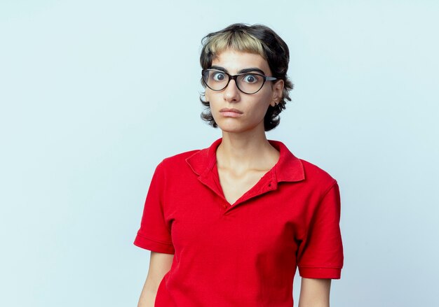 Impressionné jeune fille de race blanche avec coupe de cheveux de lutin regardant la caméra isolée sur fond blanc avec espace de copie