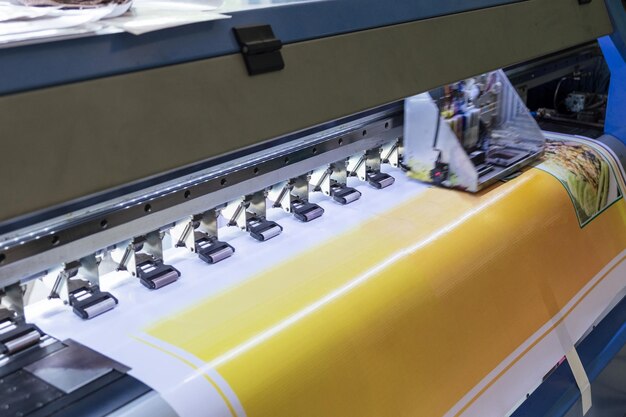 Imprimante à jet d'encre grand format travaillant sur du papier vinyle sur le lieu de travail