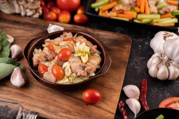 Incorporer le chou avec la poitrine de porc dans une assiette sur une assiette en bois.