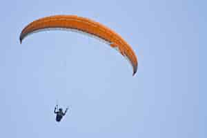 Photo gratuite incroyable coup d'un parapente humain sur ciel bleu