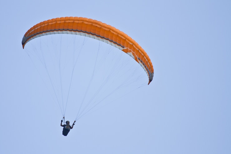 Photo gratuit incroyable coup d'un parapente humain sur ciel bleu
