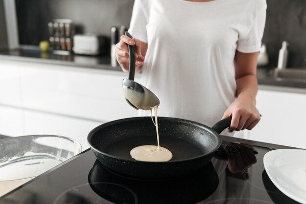 Incroyable jeune femme debout dans la cuisine à la maison