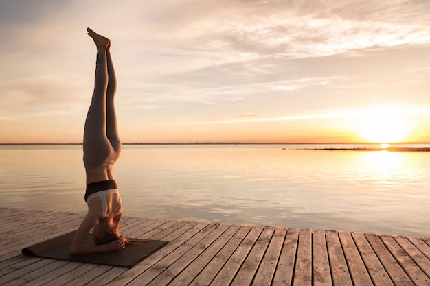 Photo gratuite incroyable jeune femme sportive fait des exercices de yoga.