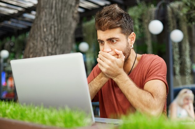 Indépendant masculin choqué et troublé, le programmeur a fait une énorme erreur dans le script, l'air inquiet à l'écran d'un ordinateur portable