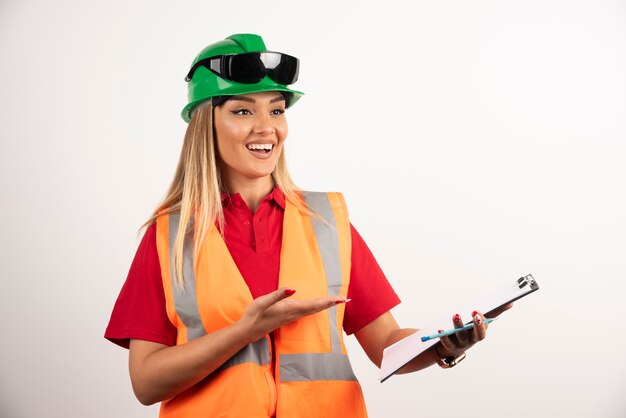 Industrie de la femme souriante portant des lunettes et un uniforme de sécurité