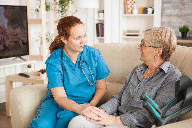 Infirmière ayant une conversation avec une femme retraitée en maison de retraite.