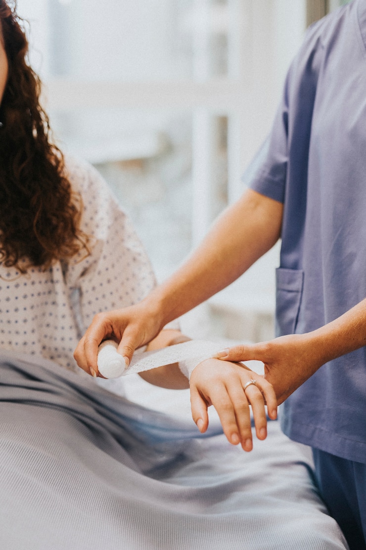 Photo gratuit infirmière bandant le bras du patient