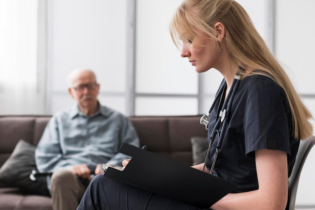 Infirmière consultant vieil homme dans une maison de soins infirmiers