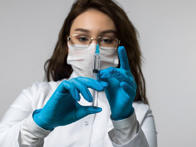 Infirmière avec injection en uniforme médical blanc