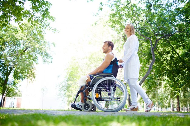 Infirmière avec le jeune homme en fauteuil roulant